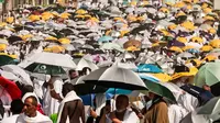 Muslim jemaah haji 2024 menggunakan payung untuk melindungi diri saat tiba di kaki Gunung Arafat selama ibadah haji tahunan. (Fadel Senna/AFP)