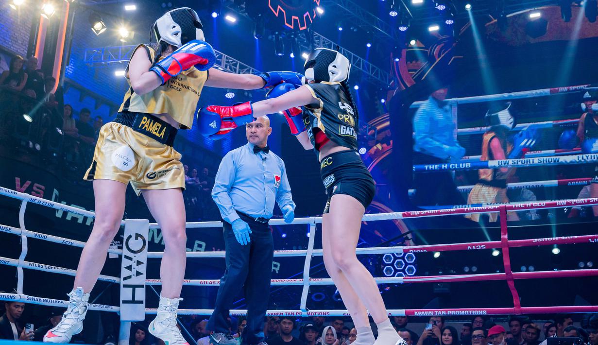 Penyanyi dangdut, Pamela Safitri (kiri), terus menggempur disjoki, Dinar Candy (kanan), dalam pertandingan tinju antar selebriti Holywings Sport Show (HSS) Series 3 yang berlangsung di Atlas Super Club, Bali, Minggu (10/9/2023). (Dok. Holywings)
