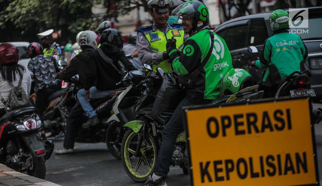 Polisi lalu lintas menindak pengendara sepeda motor saat razia Operasi Patuh Jaya 2019 di kawasan Kemanggisan, Jakarta, Kamis (29/8/2019). Diketahui, Operasi Patuh Jaya 2019 di wilayah hukum Polda Metro Jaya mulai digelar hari ini hingga 11 September 2019. (Liputan6.com/Faizal Fanani)