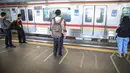 Penumpang berdiri di garis antrean penumpang di Stasiun Juanda, Jakarta, Kamis (10/8). PT KAI Commuter Jabodetabek melakukan uji coba garis antrean penumpang tersebut guna untuk keselamatan bagi para penumpang. (Liputan6.com/Faizal Fanani)