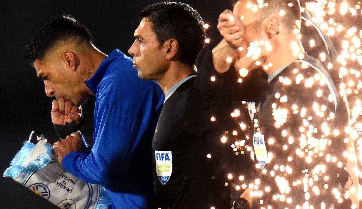 Pemain Uruguay, Luis Suarez (kiri) memasuki lapangan saat laga kualifikasi Piala Dunia 2026 melawan Paraguay yang berlangsung di Stadion Centenario, Montevideo, Uruguay, Sabtu (07/09/2024) WIB. (AFP/Dante Fernandez)