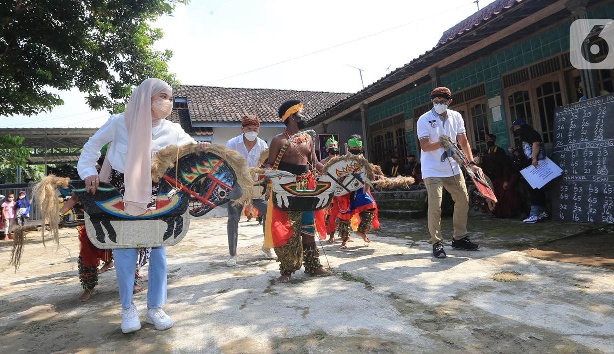 <p>Menteri Pariwisata dan Ekonomi Kreatif (Menparekraf) Sandiaga Salahudin Uno (kanan), youtuber Mitty Zasia dan public figur Ananda Omesh (Omesh) menari jathilan di desa wisata Candirejo, Kabupaten Magelang, Jawa Tengah, Jumat (4/6/2021). (Liputan6.com/HO/Kemenparekraf)</p>