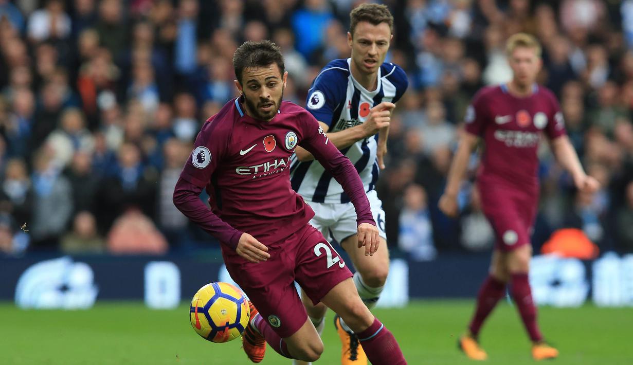 Gelandang Manchester City, David Silva, menghindari kejaran bek West Bromwich, Jonny Evans, pada laga Premier League di Stadion The Hawthorns, West Bromwich, Sabtu (28/10/2017). West Bromwich kalah 2-3 dari City. (AFP/Lindsey Parnaby)