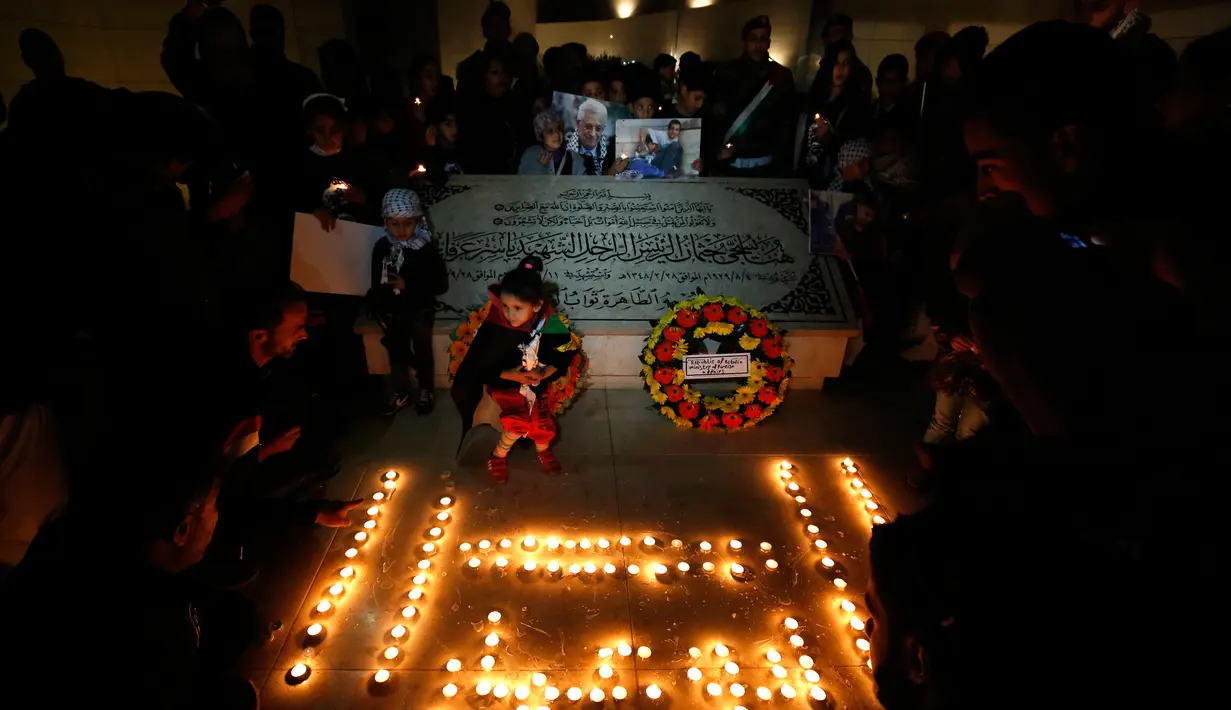 Warga Palestina menyalakan lilin dalam acara renungan menjelang peringatan 11 tahun wafatnya mantan Presiden Yasser Arafat, di Ramallah, Tepi Barat, Selasa (10/11) malam waktu setempat. (AFP PHOTO / ABBAS Momani)