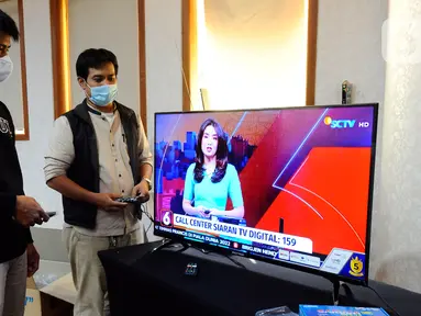 Petugas Kementerian Komunikasi dan Informatika (Kemenkominfo) menyampaikan penjelasan penggunaan alat Set Top Box (STB) yang dibagikan secara gratis kepada warga di Posko Respon Cepat Penanganan Bantuan STB di Hotel Bumi Wiyata, Depok, Jawa Barat, Rabu (2/11/2022). Kemenkominfo membuka posko penanganan bantuan STB sebagai perangkat konverter siaran TV digital ke televisi jenis analog bagi warga Jabodetabek yang akan mengikuti Analog Switch Off (ASO) di 2 November 2022 tengah malam. (merdeka.com/Arie Basuki)