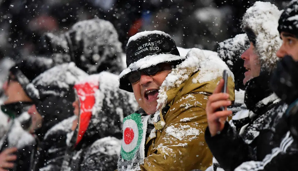 Seorang fans saat berada di Allianz Stadium di Turin, Italia, (25/2). Italia saat ini sedang dilanda cuaca ekstrem yang dianggap jadi puncaknya musim dingin sebelum peralihan musim semi. (AFP Photo/Alberto Pizzoli)