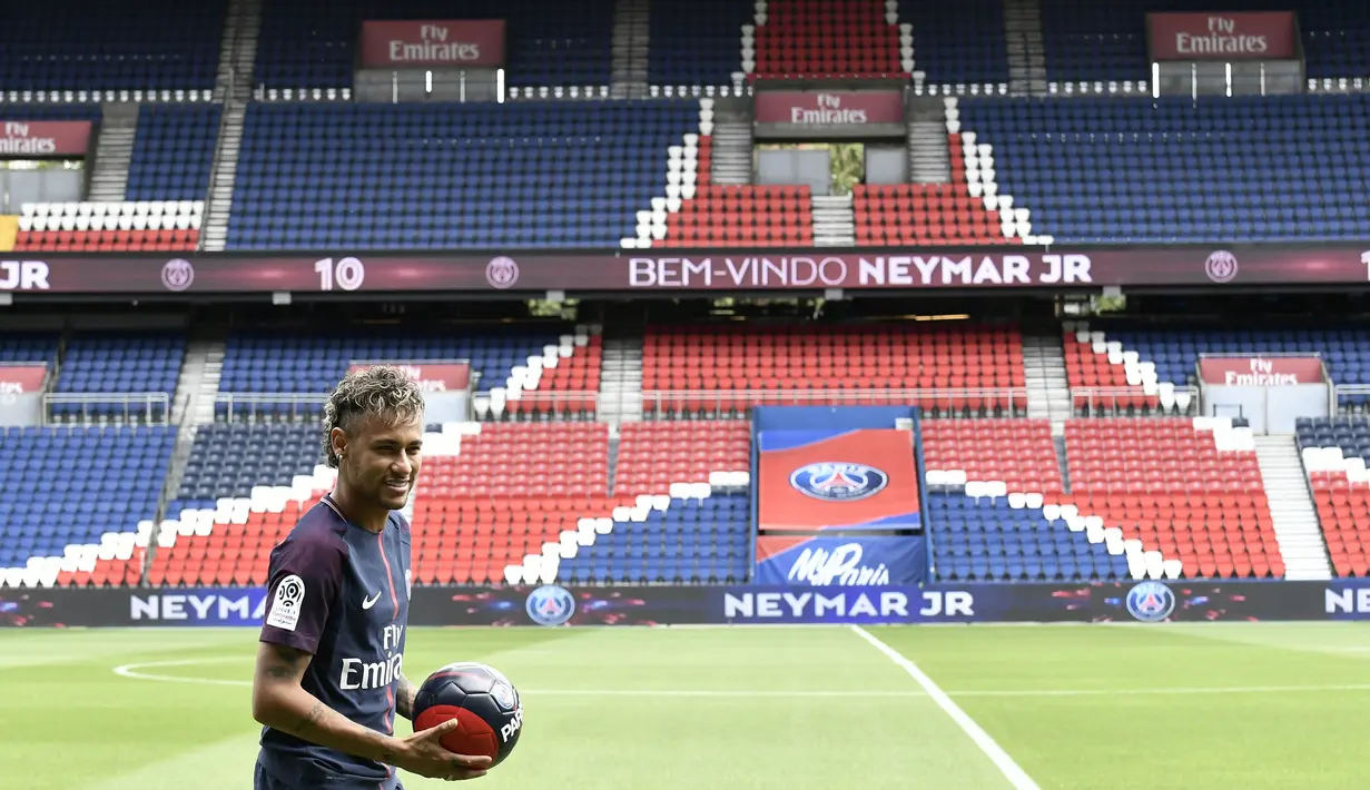 Bintang Brasil, Neymar, melempar senyum saat diperkenalkan sebagai pemain baru PSG di Stadion Parc des Princes, Paris, Jumat (4/8/2017). Neymar didatangkan dari Barcelona dengan harga 222 juta euro. (AFP/Philippe Lopez)