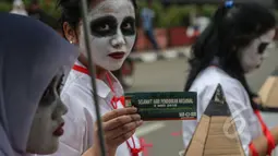 Mahasiswa melakukan aksi teatrikal bertema 'Revolusi Pendidikan' dalam rangka memperingati Hari Pendidikan Nasional di Bundaran HI, Jakarta, Minggu (3/5/2015). Tampak para mahasiswa merias wajah mereka.(Liputan6.com/Faizal Fanani) 
