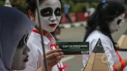 Mahasiswa melakukan aksi teatrikal bertema 'Revolusi Pendidikan' dalam rangka memperingati Hari Pendidikan Nasional di Bundaran HI, Jakarta, Minggu (3/5/2015). Tampak para mahasiswa merias wajah mereka.(Liputan6.com/Faizal Fanani) 