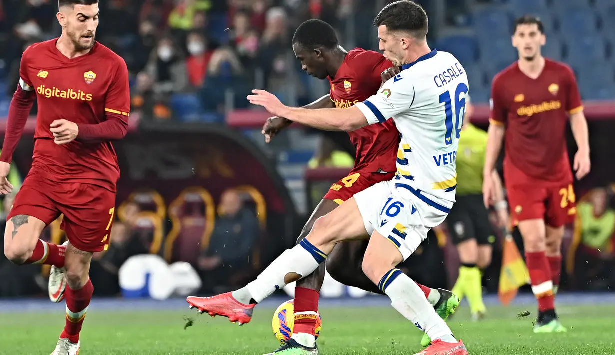 Penyerang AS Roma Felix Afena (tengah merah) berebut bola dengan bek Hellas Verona Nicolo Casale pada pekan ke-26 Liga Italia di Olimpico, Minggu (20/2/2022) dini hari WIB. AS Roma ditahan imbang Verona dengan skor 2-2. (Andreas SOLARO / AFP)
