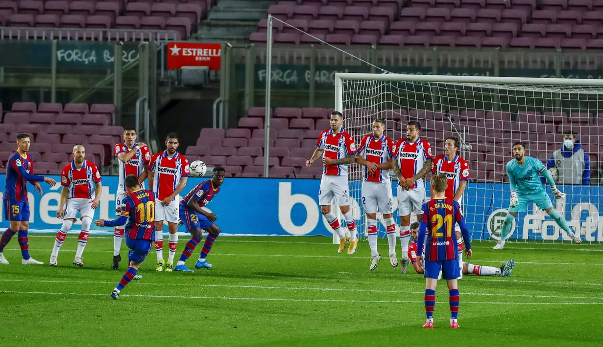 Striker Barcelona, Lionel Messi, melepaskan tendangan bebas saat melawan Alaves pada laga Liga Spanyol di Stadion Camp Nou, Sabtu (14/2/2021). Barcelona menang dengan skor 5-1. (AP Photo/Joan Monfort)