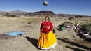Seorang perempuan suku Aymara berusaha menyundul bola di distrik Juli, kota Puno, Peru selatan. (AFP/Carlos Mamani)