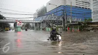 Pengendara motor menerobos banjir yang menggenangi Jalan Gunung Sahari, Pademangan, Jakarta Pusat, Selasa (21/2). Banjir setinggi pinggang orang dewasa menyebabkan terputusnya sejumlah akses jalan untuk kendaraan bermotor. (Liputan6.com/Faizal Fanani)