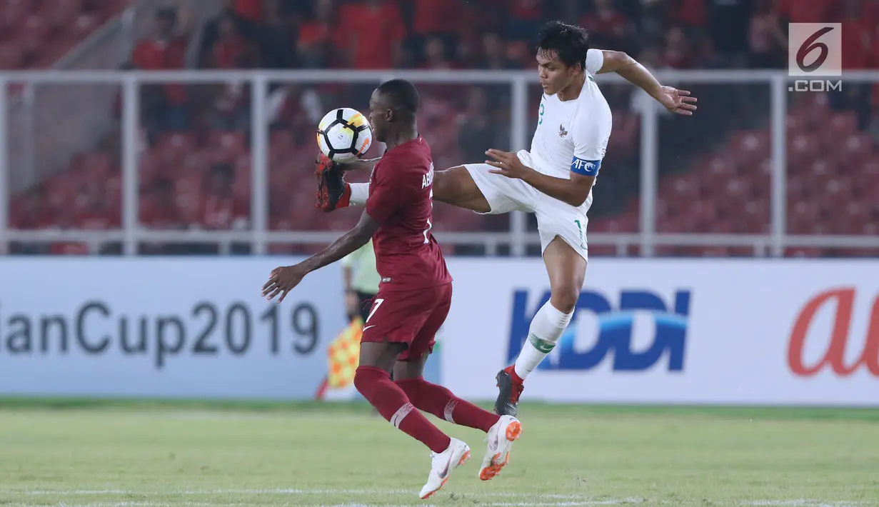 Bek Timnas Indonesia U-19, Rachmat Irianto (kanan) berebut bola dengan pemain Qatar U-19, Abdulrasheed Umaru pada penyisihan Grup A Piala AFC U-19 2018 di Stadion GBK, Jakarta, Minggu (21/10). Indonesia kalah tipis 5-6. (Liputan6.com/Helmi Fithriansyah)