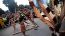 Penari berpakaian adat Dayak melakukan pertunjukan memanjat pohon manau berduri pada pawai budaya saat Car Free Day di kawasan Sudirman, Jakarta, Minggu (29/10). Kegiatan ini dikemas dengan nama Gelar Pesona Budaya Tabalong. (Liputan6.com/Faizal Fanani)
