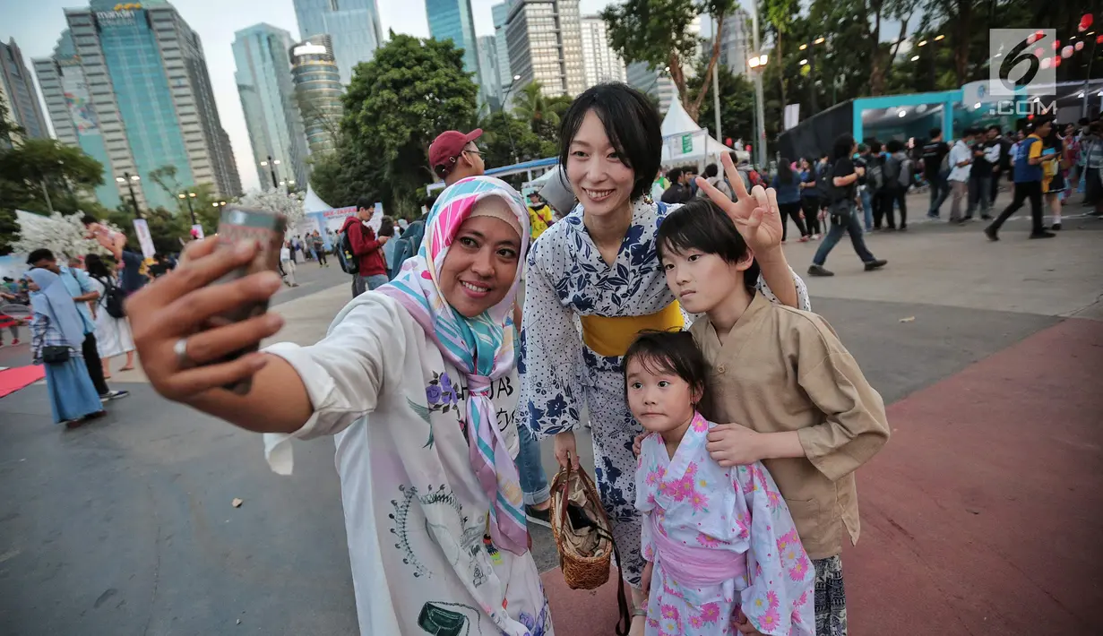 Pengunjung berswafoto dengan warga berpakaian Kimono saat hari pertama acara Jak-Japan Matsuri 2018 di Gelora Bung Karno, Senayan, Jakarta, Sabtu (8/9). Tahun ini, festival mengusung tema Indonesia and Japan Always Together. (Liputan6.com/Faizal Fanani)