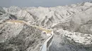 Hamparan pegunungan yang ada disekitarnya pun memutih tertutup oleh salju. (GREG BAKER/AFP)