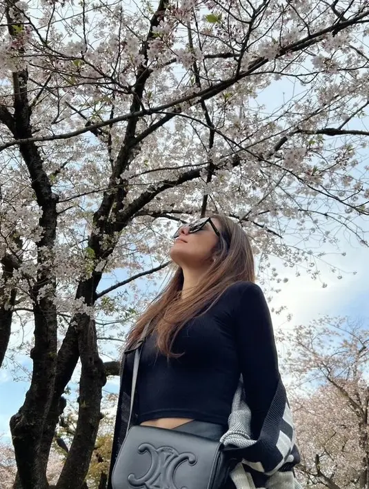 Dengan inner crop top, ibu tiga anak ini pun menggerai rambut panjang kecokelatannya. Nampak ia pun mengenakan kacamata hitam. Credit: Instagram (@wulanguritno)