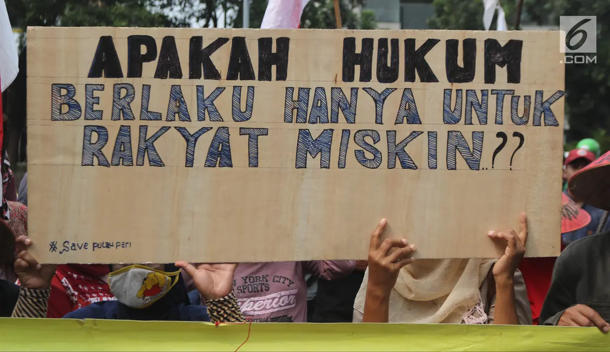 Warga Pulau Pari membawa papan bertuliskan tuntutan saat menggelar aksi di depan PN Jakarta Utara, Kamis (12/7). Mereka menolak dugaan kriminalisasi terhadap Ketua RW Pulau Pari Sulaiman dalam kasus penyerobotan lahan. (Liputan6.com/Arya Manggala)