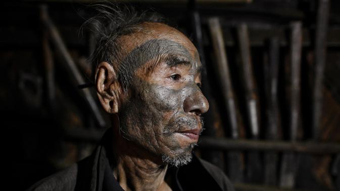 Nok Tan (75), seorang suku Konyak yang bertato saat berada dalam rumahnya di sebuah desa di wilayah Sagaing, Myanmar, 9 Februari 2020. Sejumlah suku yang tinggal di zona semi-otonom dekat perbatasan India menjadikan tato sebagai tradisi. (Ye Aung THU/AFP)