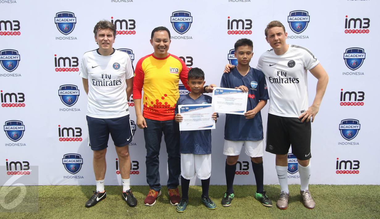  Technical Director of PSG Academy Cedric Cattenoy (kiri), Head Coach PSG Academy Benjamin Houri (kanan) dan Division Head Consumer Engagement Indosat Ooredoo Benny Hutagalung berfoto bersama anak-anak, Jakarta, (3/4). (Liputan6.com/Immanuel Antonius)