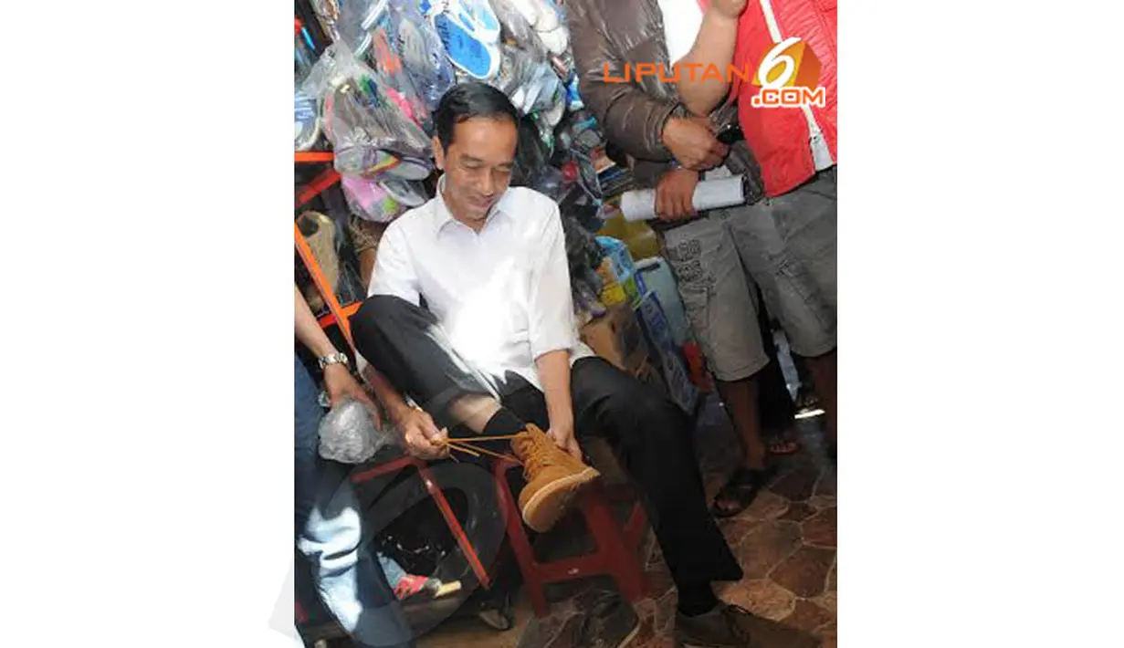 Jokowi tampak sedang menjajal sepatu yang menjadi pilihannya (Liputan6.com/Herman Zakharia)