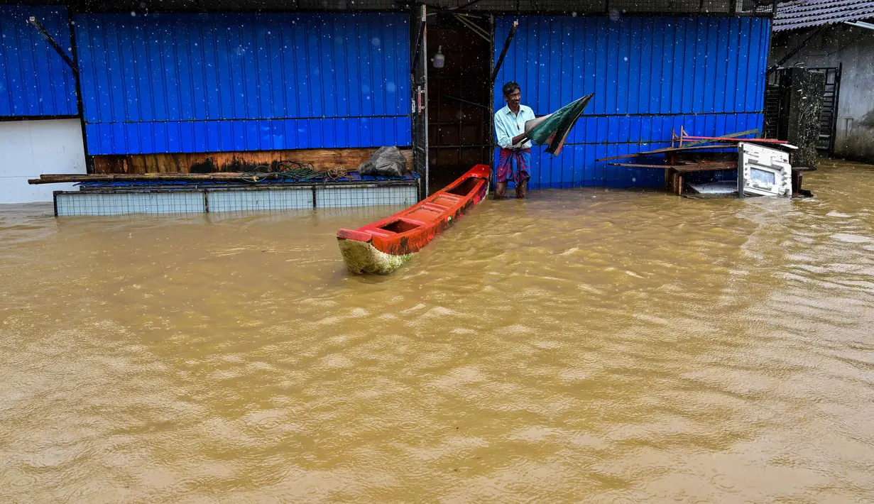 Seorang pria berdiri di luar rumahnya yang sebagian terendam banjir setelah hujan deras di Kaduwela, pinggiran Kolombo, pada Jumat 28 November 2025. Banjir dan tanah longsor yang dipicu oleh hujan deras melanda Sri Lanka. (Ishara S. KODIKARA/AFP)
