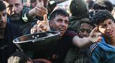 Warga Palestina yang mengungsi berebut untuk makanan di Khan Younis, selatan Jalur Gaza pada Jumat 6 Maret 2026. Krisis pangan di Gaza kembali mencapai titik kritis. Situasi ini imbas eskalasi konflik regional yang memicu penutupan seluruh pintu perlintasan perbatasan ke Gaza oleh Israel. (Bashar Taleb/AFP)