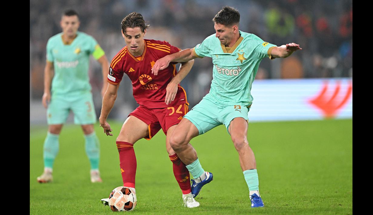 Pemain AS Roma, Edoardo Bove (kiri) berebut bola dengan pemain Slavia Praha, Lukas Masopust pada laga Grup G Liga Europa 2023/2024 di Olympic Stadium, Roma, Italia, Jumat (27/10/2023) dini hari WIB. (AFP/Alberto Pizzoli)