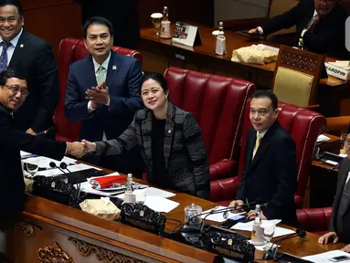 Ketua DPR Puan Maharani berjabat tangan dengan Komisioner KPU I Dewa Kade Wiarsa Raka Sandi dalam rapat paripurna di Kompleks Parlemen, Senayan, Kamis (27/2/2020). DPR resmi mengesahkan Raka Sandi menjadi komisioner KPU menggantikan Wahyu Setiawan yang terjerat kasus suap. (Liputan6.com/Johan Tallo)