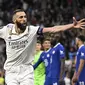 Pemain Real Madrid, Karim Benzema melakukan selebrasi setelah mencetak gol pertama timnya ke gawang Chelsea pada laga leg pertama Liga Champions 2022/2023 di Santiago Bernabeu, Madrid, Kamis (13/04/2023) WIB. Los Blancos menang dengan skor 2-0. (AFP/Javier Soriano)