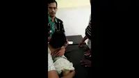 Orang tua Arfan menggendong sang anak yang meninggal akibat tersengat listrik kabel mesin pembuat roti yang sudah terkelupas. Tangkapan layar (Liputan6.com / Panji Prayitno)