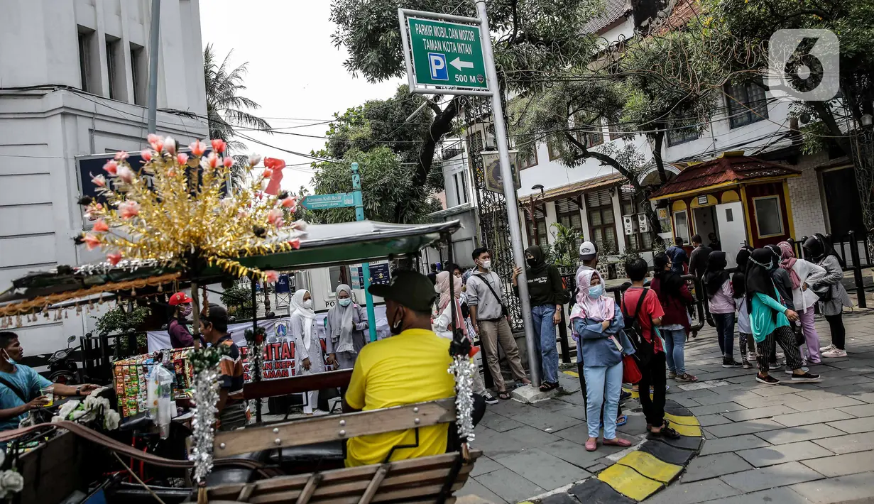 Pengunjung berkumpul di depan pintu masuk kawasan wisata Kota Tua, Jakarta, Sabtu (15/5/2021). Pemerintah Provinsi DKI Jakarta menutup kawasan wisata Kota Tua hingga 16 Mei 2021. (Liputan6.com/Faizal Fanani)