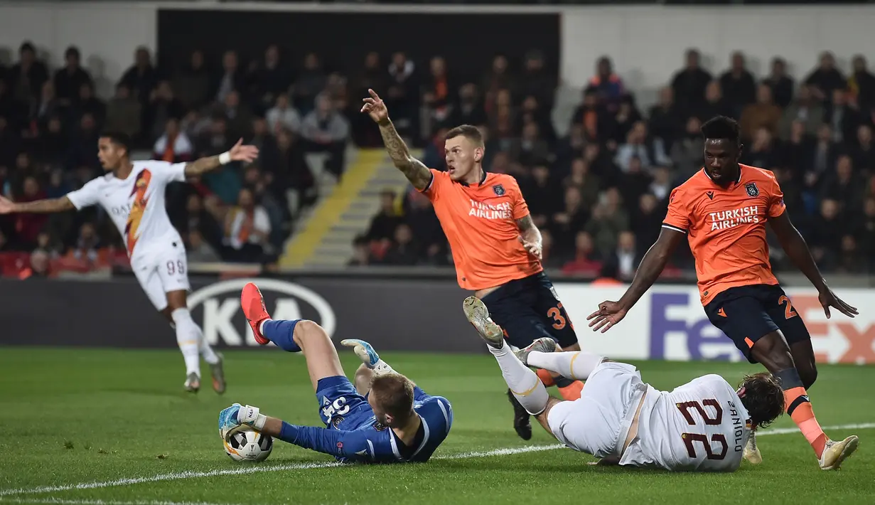Gelandang AS Roma Nicolo Zaniolo berebut bola dengan kiper Istanbul Basaksehir, Mert Gunok pada laga kelima Grup J Liga Europa 2019-2020 di stadion Fatih Terim, Kamis (28/11/2019). AS Roma menang meyakinkan dengan skor 3-0.  (Ozan KOSE / AFP)