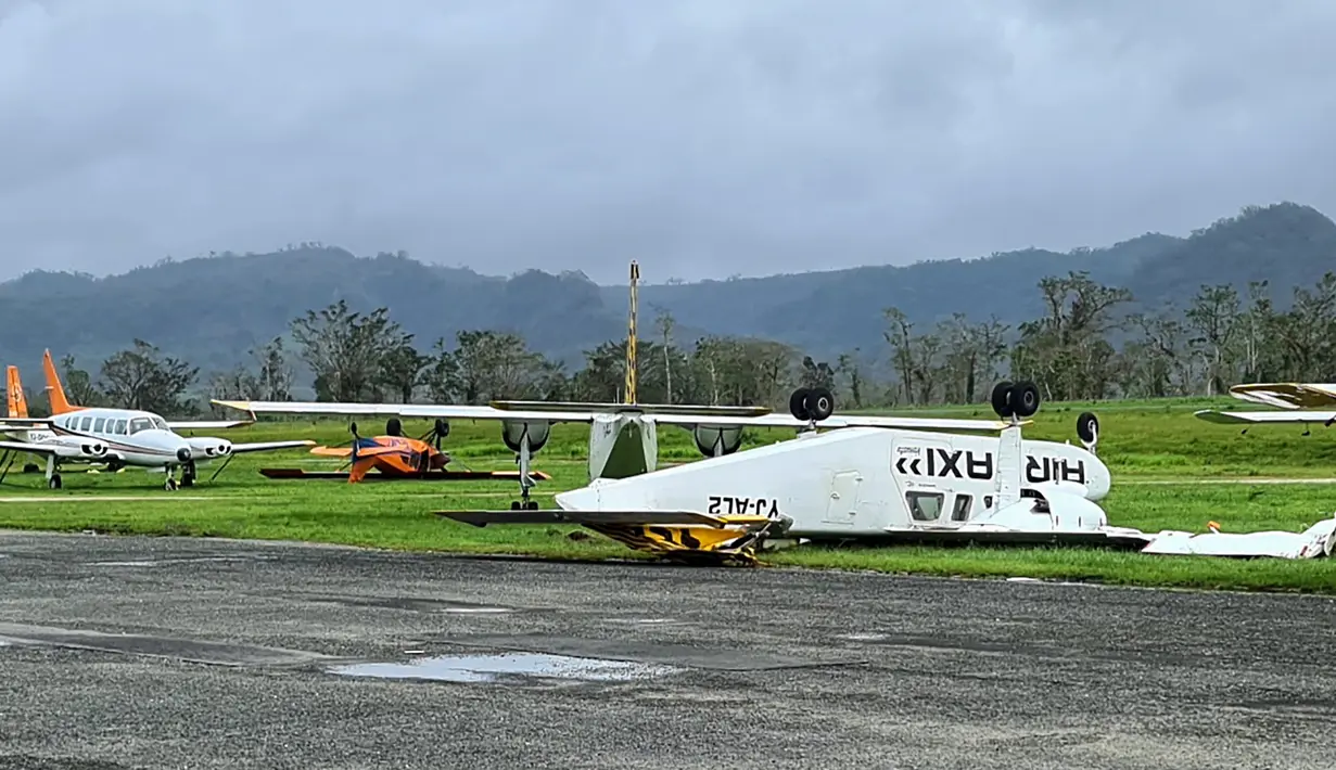 Gambar selebaran ini diambil dan dirilis pada 4 Maret 2023 oleh Jean-Baptiste Jeangène Vilmer, Duta Besar Prancis untuk Vanuatu dan Kepulauan Solomon, menunjukkan pesawat terbalik di sebelah landasan pacu di Port Vila.  Berpenduduk sekitar 300.000 orang, Vanuatu telah dinobatkan sebagai negara yang paling rawan bencana alam oleh PBB. (Jean-Baptiste Jeangène Vilmer / FRENCH EMBASSY VANUATU / AFP)