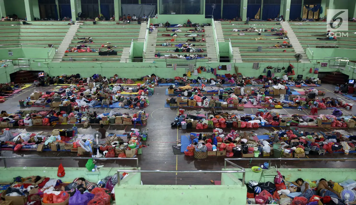 Pengungsi Gunung Agung berisitirahat di lokasi pengungsian GOR Swecapura, Klungkung, Bali, Minggu (3/12). Kurangnya sirkulasi udara membuat kondisi pengungsian menjadi lembab dan panas sehingga mengurangi kenyamanan. (Liputan6.com/Immanuel Antonius)