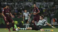 Striker Barcelona, Luis Suarez, menghindari tekel bek Sporting Lisbon, Sebastian Coates, pada laga Liga Champions di Stadion Alvalade, Lisbon, Rabu (27/9/2017). Sporting kalah 0-1 dari Barcelona. (AFP/Armando Franca)