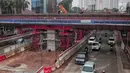 Kendaraan melintas di bawah pembangunan proyek Light Rail Transit (LRT) Jabodebek fase I di kawasan Cawang, Jakarta, Senin (14/1). Progres konstruksi stasiun LRT Cawang, Jakarta Timur sudah mencapai 62,2 persen. (Liputan6.com/Faizal Fanani)