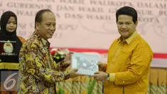 Menristek Dikti, Mohammad Nasir (kiri) bertukar cinderamata dengan Ketua KPU, Husni Kamil di Kantor KPU, Jakarta, Kamis (30/7/2015). Penandatangan terkait kerjasama verifikasi ijazah dalam rangka Pilkada serentak. (Liputan6.com/Faizal Fanani)