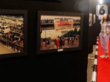 Pengunjung melihat deretan foto gerakan mahasiswa 1998 pada Pemeran Foto 25 Tahun Reformasi di Graha PENA 98, Jakarta, Kamis (11/5/2023). (Liputan6.com/Angga Yuniar)
