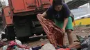 Warga memilah sampah sisa banjir yang menumpuk di kawasan Cipinang Melayu, Jakarta, Rabu (8/1/2020). Banjir yang melanda Jakarta dan sekitarnya sejak 1 Januari 2020 lalu menyisakan tumpukan sampah di sejumlah titik. (Liputan6.com/Herman Zakharia)