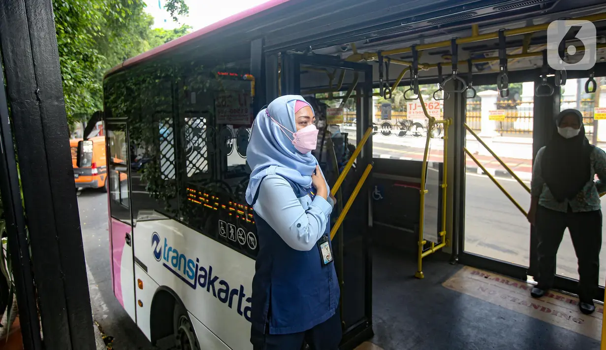 Seorang petugas layanan bus Transjakarta khusus wanita menunggu penumpangg di kawasan Pasar Baru, Jakarta, Rabu (27/7/2022). Pelayanan bus pink ini merupakan salah satu upaya Transjakarta ikut menangani masalah pelecehan dalam transportasi publik. (Liputan6.com/Faizal Fanani)
