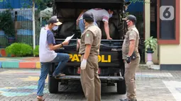 Warga pelanggar PSBB diangkut mobil Satpol PP di Tangerang, Kamis (14/5/2020). Pemkot Tangerang melakukan tindakan bagi pelanggar PSBB seperti tidak menggunakan masker dengan membawa mereka ke kantor Kecamatan Karawaci Baru untuk dilakukan pemeriksaan Rapid Test COVID-19. (Liputan6.com/Angga Yuniar)