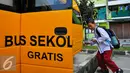 Siswa saat menaiki bus gratis di halaman rusun Muara Kapuk, Jakarta, Jumat (22/4/2016). Dua unit Bus gratis ini akan melewati rute Teluk Gong, Bandengan dan Jembatan Lima. (Liputan6.com/Yoppy Renato)