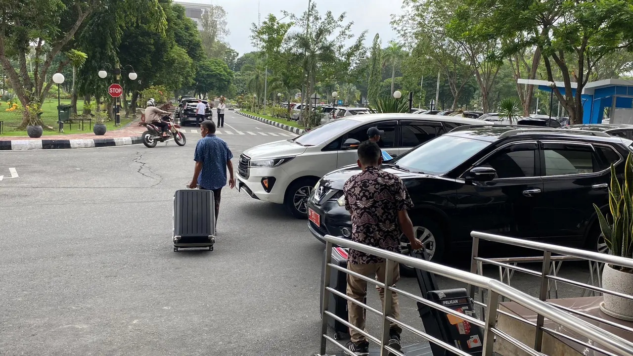 Penyidik KPK membawa koper diduga berisi dokumen pengadaan pembangunan jembatan SKA Pekanbaru.