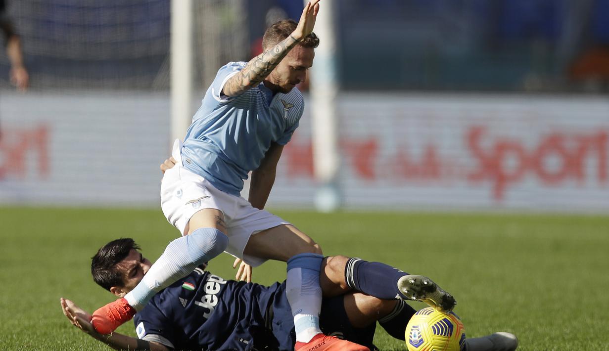 Striker Juventus, Alvaro Morata (bawah) berebut bola dengan pemain Lazio, Manuel Lazzari, dalam lanjutan Liga Italia Serie A di Stadion Olimpico, Roma, Minggu (8/11/2020). Juventus bermain imbang 1-1 dengan Lazio. (AP Photo/Andrew Medichini).