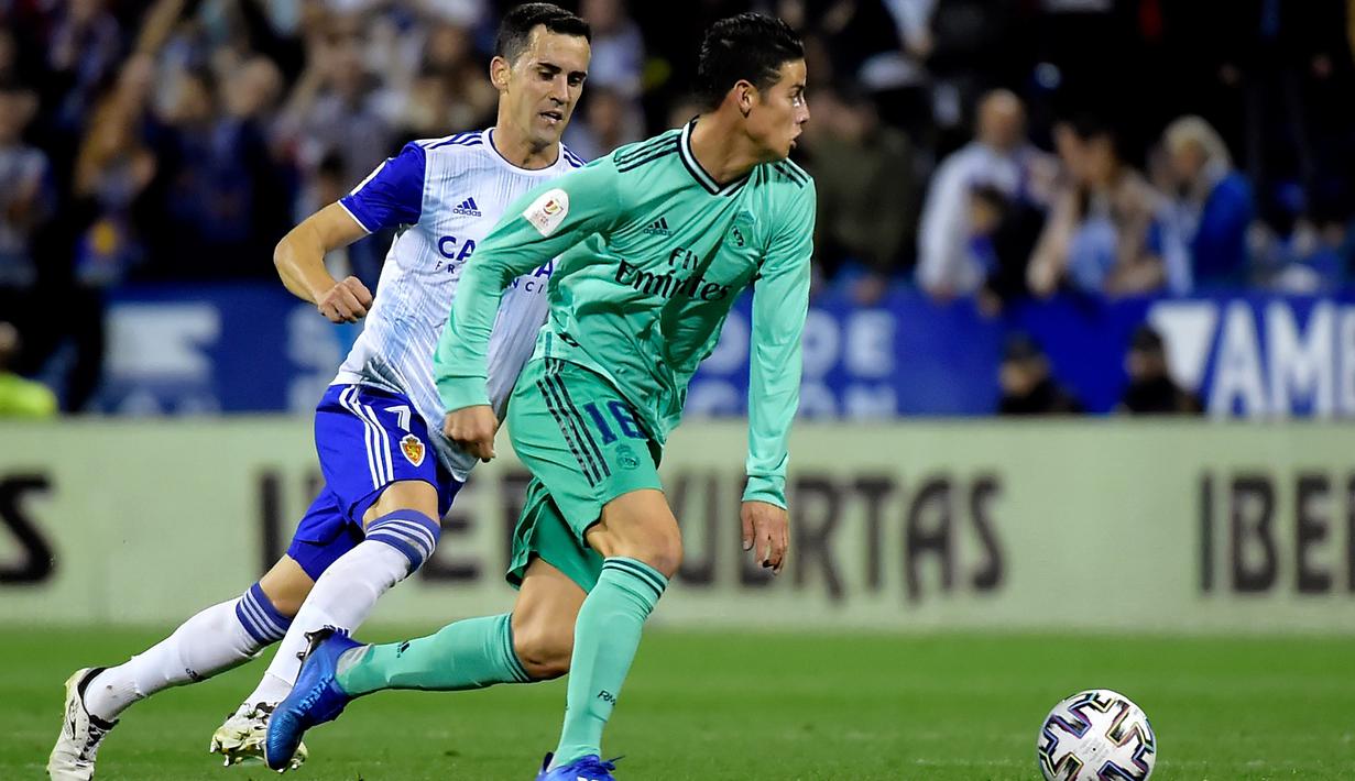 Penyerang Real Madrid, James Rodriguez menggiring bola dari kawalan penyerang Real Zaragoza, Miguel Linares  pada pertandingan Copa del Rey di stadion La Romareda, Zaragoza (29/1/2020). Real Madrid melaju mantap ke perempatfinal Copa del Rey setelah mengalahkan Zaragoza 4-0. (AFP Photo/Jose Jordan)