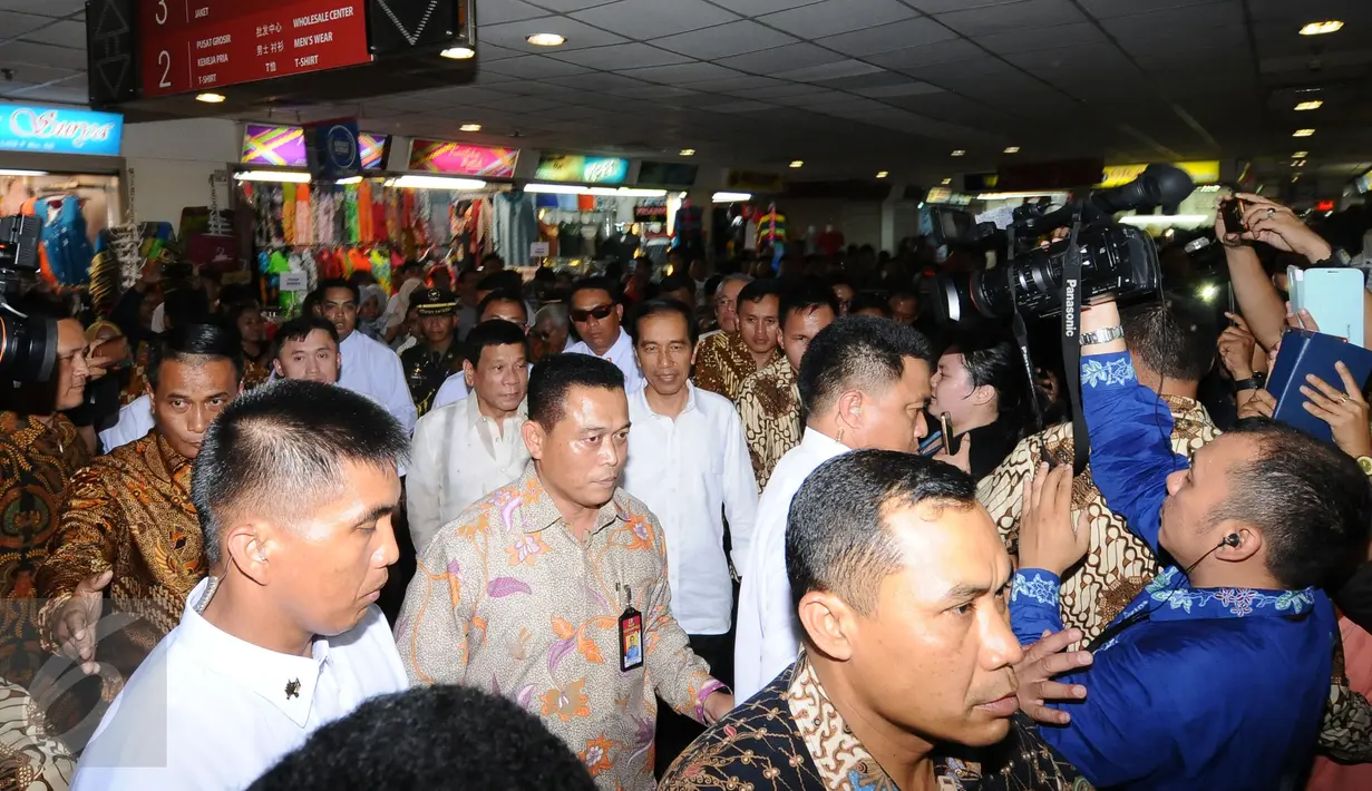 Presiden RI Joko Widodo (tengah baju putih) berjalan bersama Presiden Republik Filipina ‎Rodrigo Roa Duterte di Pasar Blok B Tanah Abang Jakarta, Jumat (9/9). Jokowi mengajak Duterte blusukan di Pasar Tanah Abang. (Liputan6.com/Helmi Fithriansyah)
