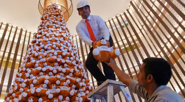 Seorang staff menyusun pohon Natal yang terbuat dari boneka beruang teddy di lobi sebuah hotel di Bangalore, India, Rabu (28/11). Ratusan boneka beruang disusun sedemikian rupa hingga membentuk pohon natal cantik. (MANJUNATH KIRAN / AFP)