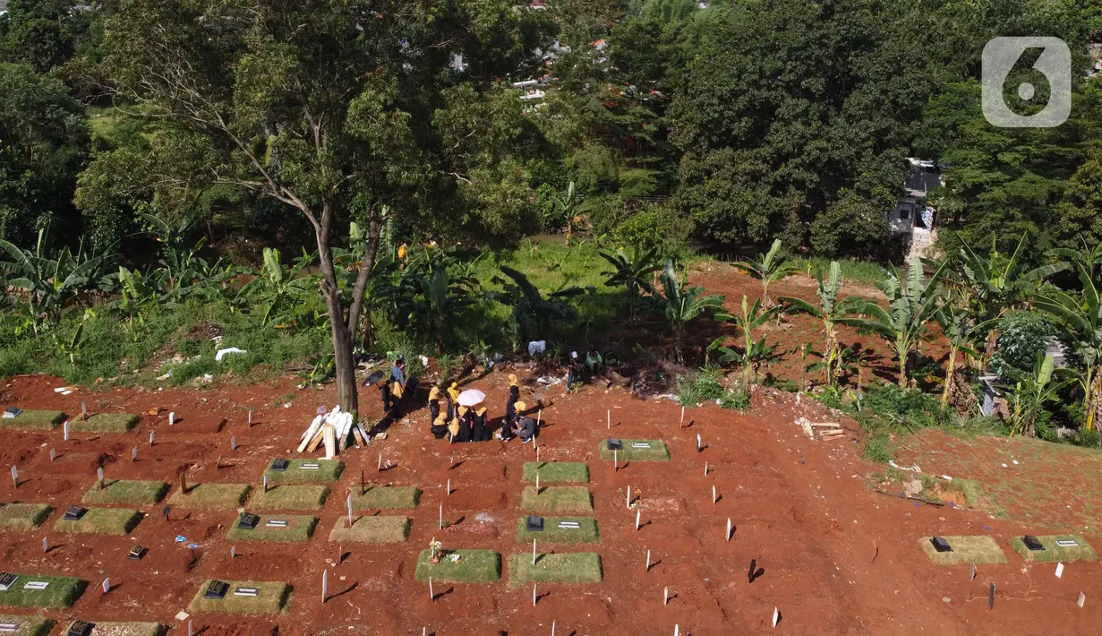 Foto aerial peziarah berdoa di sisi makam jenazah yang diduga terinfeksi virus COVID-19 di TPU Pondok Ranggon, Jakarta, Minggu (24/5/2020). Berdasar data pemerintah per 24 Mei 2020, 22.271 orang positif Corona, 1.372 meninggal dunia dan 5.402 dinyatakan sembuh. (Liputan6.com/Helmi Fithriansyah)